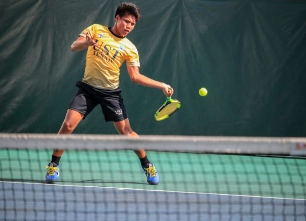 A man playing tennis about to hit a forehand.